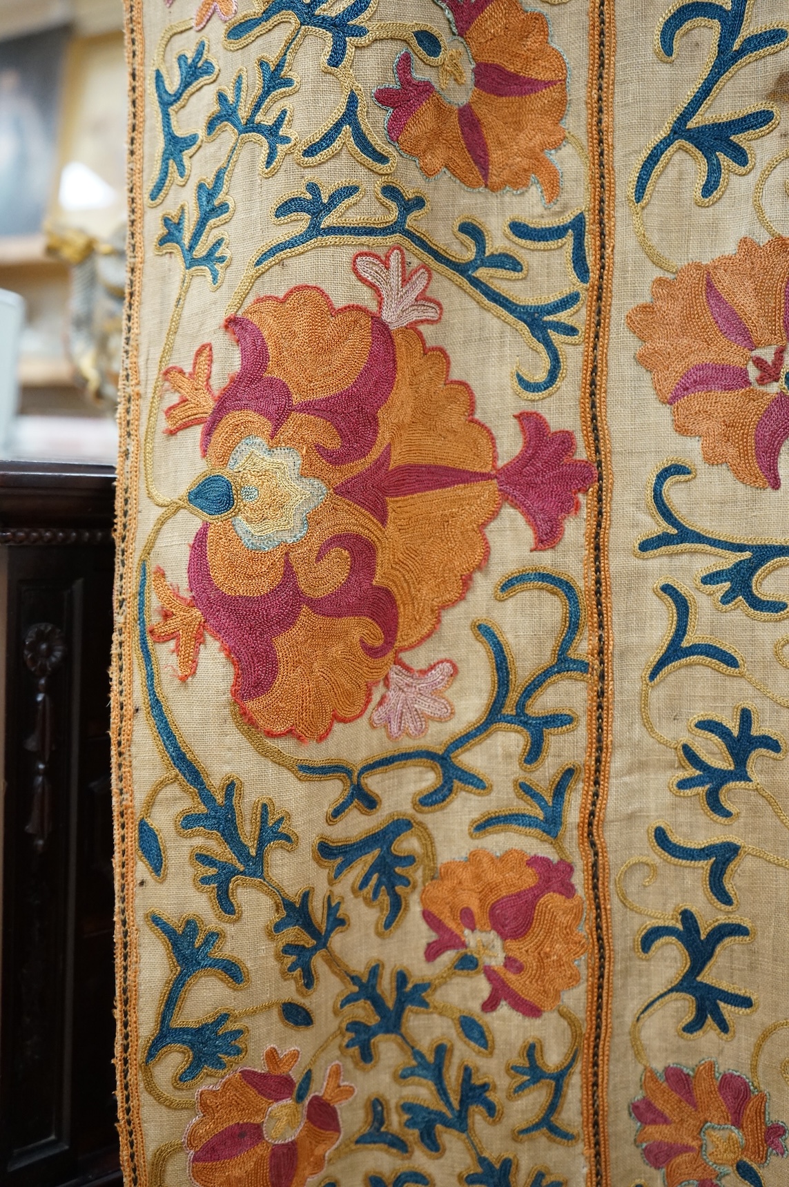 A 19th century, circa 1850-1880 hand embroidered Suzani wall hanging, probably from Uzbekistan. Worked on had woven linen, predominantly embroidered in orange, ochre, maroon and green silks in fine chain stitch with an o